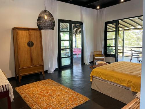 a bedroom with a bed and a door to a patio at Villa Rawarawa Private Beachfront in Central of Lovina by GEMA MANAGEMENT BALI in Lovina