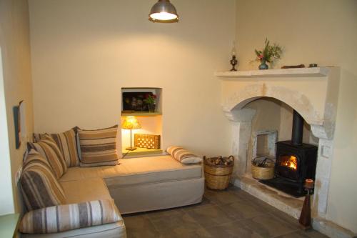 a living room with a couch and a fireplace at Agapi Holiday House in Sívas