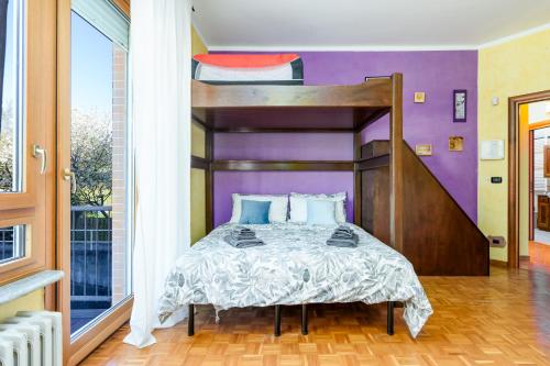 a bed in a room with a purple wall at Natura e Golf con giardino privato in Fiano