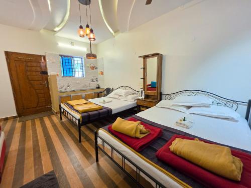a room with two beds and a bathroom at Chithralaya Guest House in Yercaud