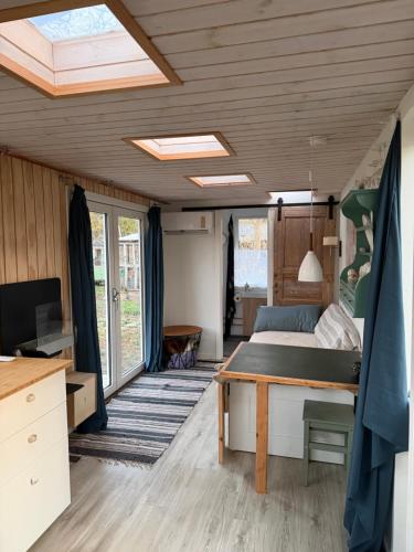 a bedroom with a bed and a desk in a room at Tiny house close to Copenhagen in Nybølle