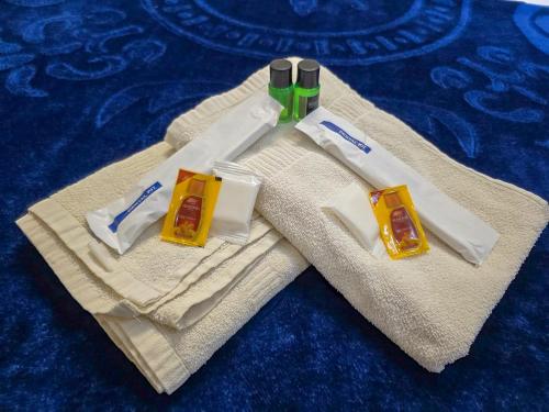 three complimentary toothbrushes and toothpaste sitting on a towel at Chithralaya Guest House in Yercaud