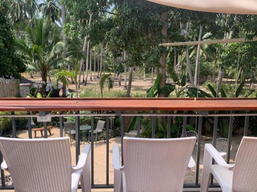 ein Tisch mit Stühlen und ein Tisch und Bäume in der Unterkunft TRIBE by Aforetime in Taling Ngam Beach