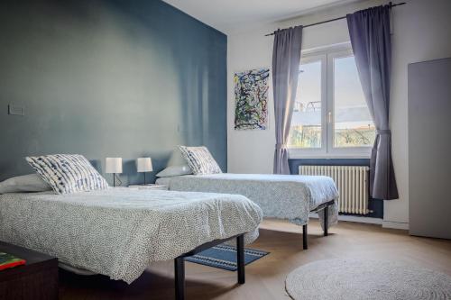 a bedroom with two beds and a window at Casa Fenice in Romano D'Ezzelino