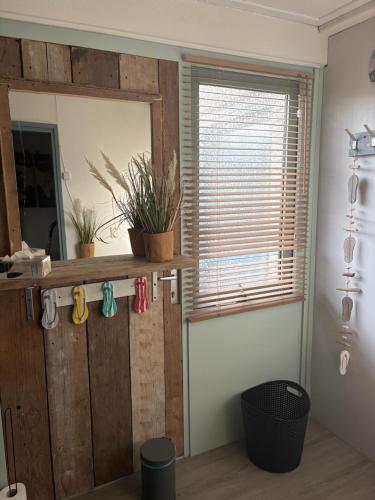 a room with a wooden door and a window at Waves in De Koog