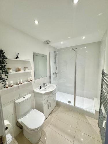 a white bathroom with a toilet and a shower at Literally Central Brighton Sleeps 8 in Brighton & Hove