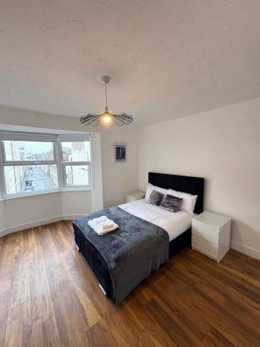 a bedroom with a large bed and a large window at Literally Central Brighton Sleeps 8 in Brighton & Hove