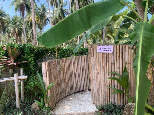 ein Holzzaun mit einem Schild, auf dem „Garten“ steht in der Unterkunft TRIBE by Aforetime in Taling Ngam Beach