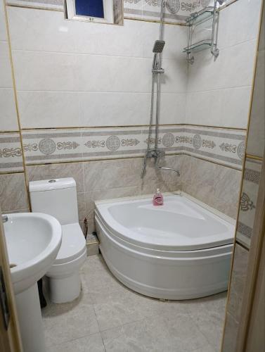 a bathroom with a toilet and a tub and a sink at COMFORT house in Khiva