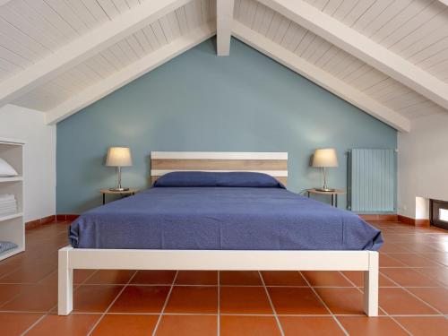 a bedroom with a blue bed with two lamps at Villa Floro in Azzano d'Asti
