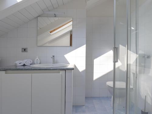 a white bathroom with a sink and a toilet at Villa Floro in Azzano d'Asti