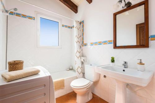 a bathroom with a sink toilet and a mirror at Villa Vientosol by Villa Plus in Cala en Forcat