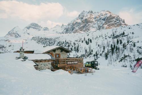 a cabin in the snow in front of a mountain at Rifugio Baita Belvedere in Champoluc