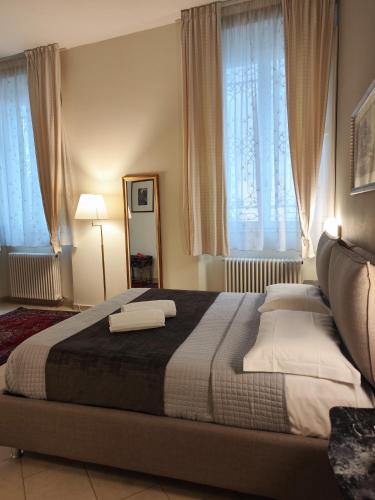 a bedroom with a large bed with two pillows at Maison Rebecca - Superior Suite Apartment in Ravenna