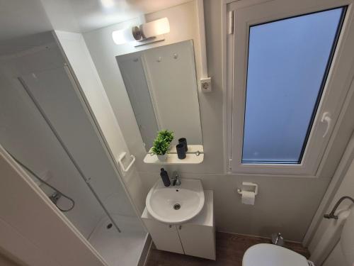 a bathroom with a sink and a toilet and a window at Glamour Pakoštane Mobile Home in Pakoštane