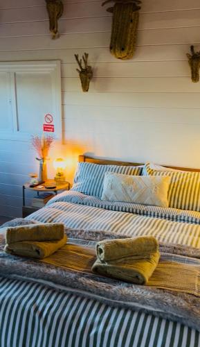 a bedroom with a bed with two towels on it at Cwt Gafr Bach in Pwllheli