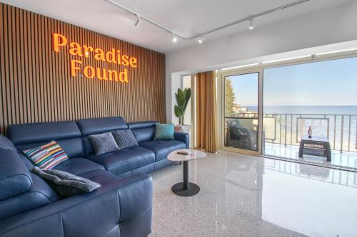 a living room with a blue couch and a signgraduate fund at Seaview Escape I 60 seconds to the Beach in St. Julianʼs
