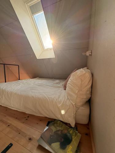 a bed in a small room with a window at 44Møen in Askeby