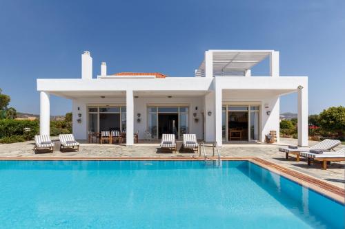 a villa with a swimming pool and a house at Belvedere Beachfront Villa in Afantou
