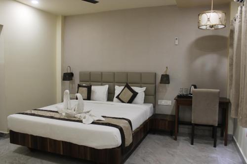 a bedroom with a bed and a desk and a chair at Amar Resorrt in Motīhāri