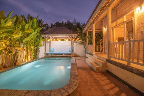 a swimming pool in the backyard of a house at Wana Shanti Villa in Bringkit