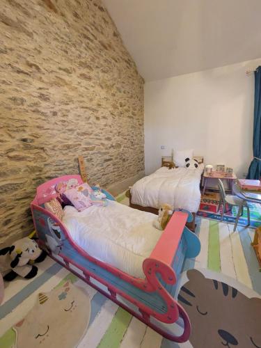 a bedroom with two beds and a stone wall at chambre chez hote familiale 2, 4, 5,6 in Mareuil-sur-Lay