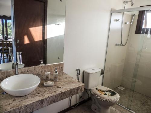 a bathroom with a sink and a shower and a toilet at Casa Viva in Imbituba