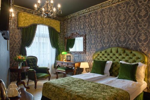 a bedroom with a bed with a green headboard at SleepWalker Boutique Suites in Wrocław
