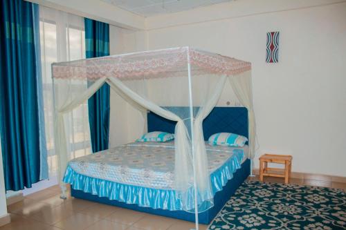 a bedroom with a bed with a canopy at Fido's Guesthouse in Ruhengeri