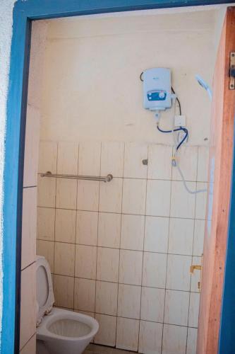 a small bathroom with a toilet and a shower at Fido's Guesthouse in Ruhengeri