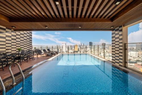a swimming pool with a view of a building at Mitisa Hotel Da Nang - Near Dragon Bridge in Danang