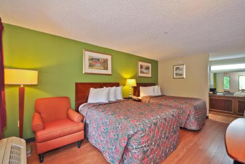 a hotel room with a bed and a chair at Country Hearth Inn & Suites Marietta in Atlanta