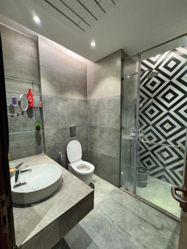 a bathroom with a sink and a toilet and a shower at Shagun Stays in Greater Noida