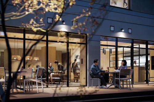 a group of people sitting at a table outside a building at Fairfield by Marriott Hyogo Awaji Fukura in Minamiawaji