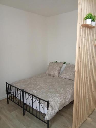 a bed in a room with a wooden bed frame at Le cocon en Champagne in Avize