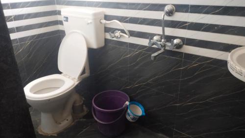 a bathroom with a toilet and a sink and a bucket at jAYESH PALACE in Loni Kālbhor