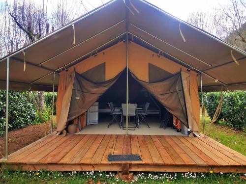 a tent with a wooden floor and a table in it at Camping le Terriol - Onlycamp in Cajarc