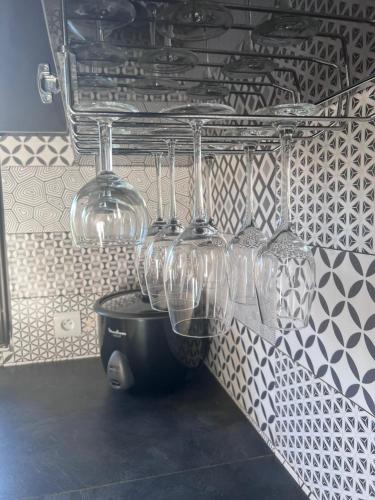 a row of wine glasses hanging on a wall at Akany Fitahiantsoa in Ivato
