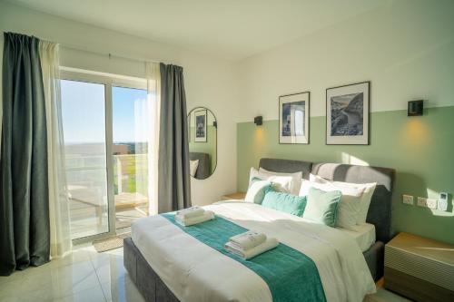 a bedroom with a large bed with a large window at Pietro Boutique Hotel and Villas in Għarb