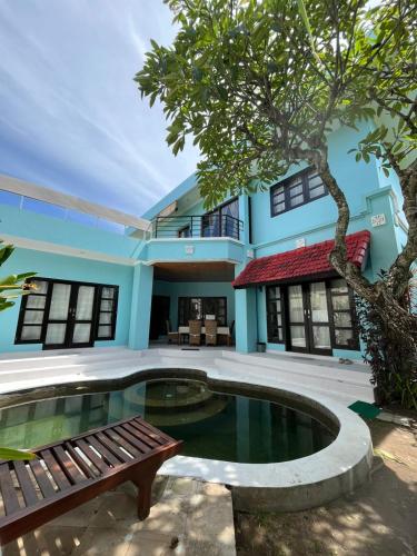 a house with a pool and a bench in front of it at Nipper Resort & Villa Nusa Dua in Ujung