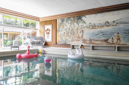 a swimming pool with three swans in the water at Bartl Apartments in Rottach-Egern