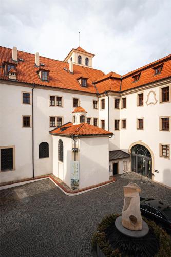 a large white building with a red roof at Augustine Hotel, Prague in Prague
