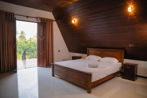 a bedroom with a bed with a wooden wall at King coco villa in Tangalle