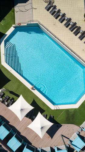 an overhead view of a swimming pool with chairs and umbrellas at Residence on Langley Park in Perth