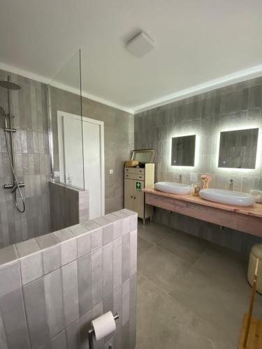 a bathroom with two sinks and two mirrors at A casa das hortênsias- caminho de Santiago in São Pedro da Torre