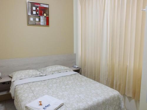 a hotel room with a bed and a window at Hostal Gazu in Chiclayo