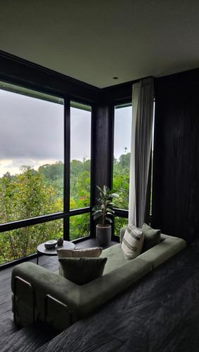a living room with a couch and large windows at The Bataran Studio in Gitgit