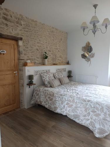 a bedroom with a bed and a brick wall at Chambre d'hôtes - Retour à la ferme in Verteillac
