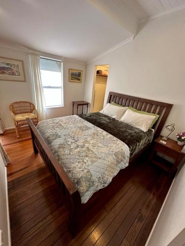 a bedroom with a large bed and a window at Lemon Cottage in Rous Mill