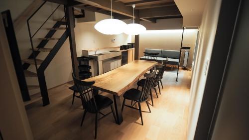 a dining room with a long table and chairs at ゲストハウスとわ in Kanazawa